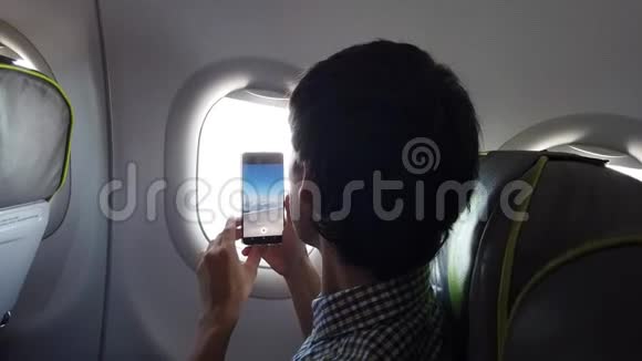 年轻人在电话中从飞机窗口拍摄一张照片视频的预览图