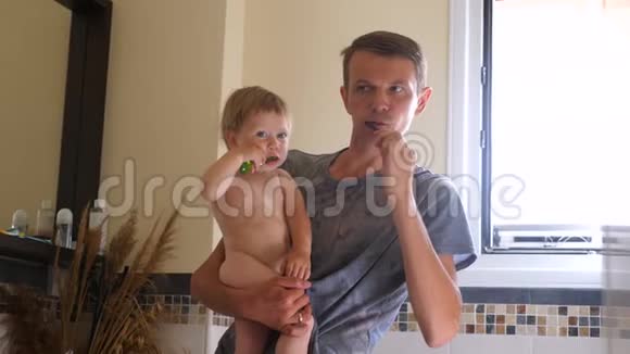 爸爸和孩子在浴室刷牙刷牙背景家庭牙齿护理牙刷和婴儿第一批视频的预览图