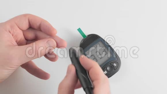 一个不被承认的人测量血糖葡萄糖用笔将手指的皮肤刺穿并涂上一滴血视频的预览图