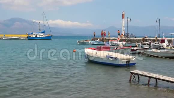 旅行概念渔船上的海水和码头上的年轻人旅游背景希腊的景色大海视频的预览图