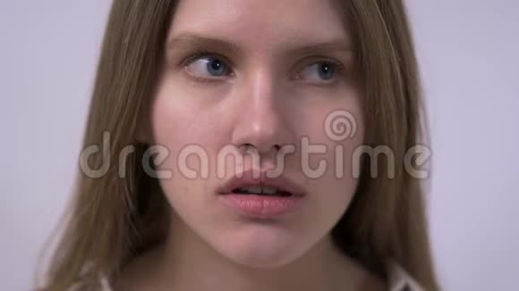 一个非常自信体贴的女孩的特写肖像手靠近脸严肃地抬头站在上面视频的预览图