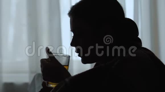 患病妇女喝茶打喷嚏流感流行在家治疗的阴影视频的预览图