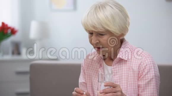 悲伤的老年妇女吃药老年健康问题昂贵的药物视频的预览图