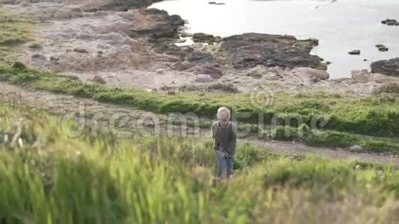 一个金发男孩在海边散步视频的预览图