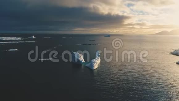 南极洲上空日落时的冰雪冰山前空中跟踪视图视频的预览图