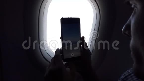 年轻人在电话中从飞机窗口拍摄一张照片视频的预览图