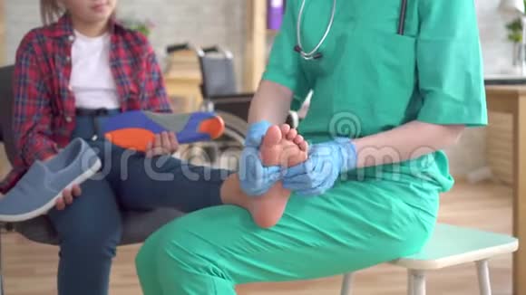 医生揉捏一个有整形问题的少女的脚视频的预览图