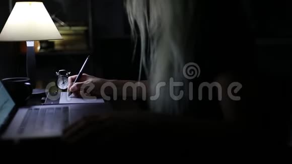 在笔记本电脑键盘上输入女性手的特写并使用图形平板电脑和手写笔视频的预览图