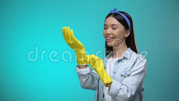 漂亮的家庭主妇戴着手套在镜头前做手势打扫卫生视频的预览图