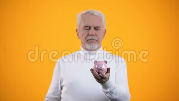 老年男性在储蓄罐里投硬币预算低养老金观念低视频的预览图