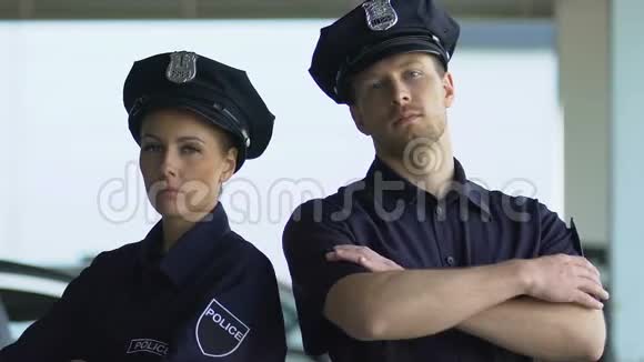 戴帽子的严肃警察在镜头前摆姿势地区保安视频的预览图