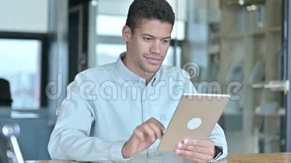 英俊的非洲男人在桌上做视频聊天视频的预览图