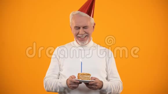 开朗的老人吹生日蛋糕蜡烛庆祝节日心情好视频的预览图
