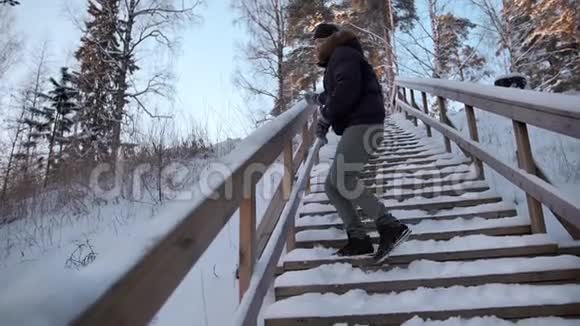 年轻男子从楼梯栏杆和照相机扔雪视频的预览图