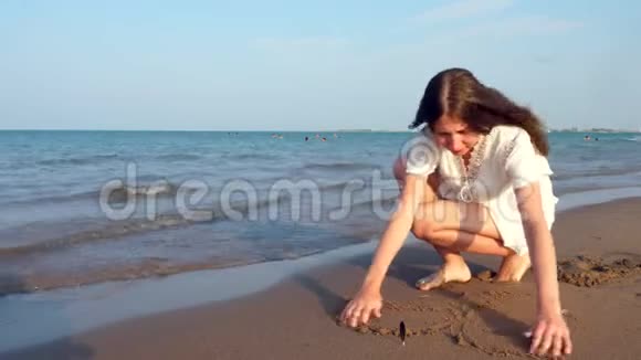 孤独的少女在沙滩上画一颗心视频的预览图