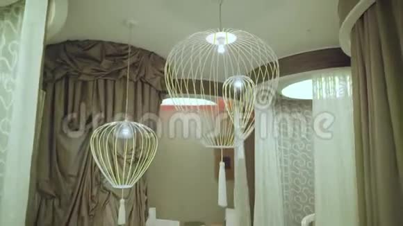 悬挂在休息室内的鸟笼状灯具视频的预览图