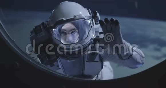 太空人漂浮在太空船的窗户上视频的预览图
