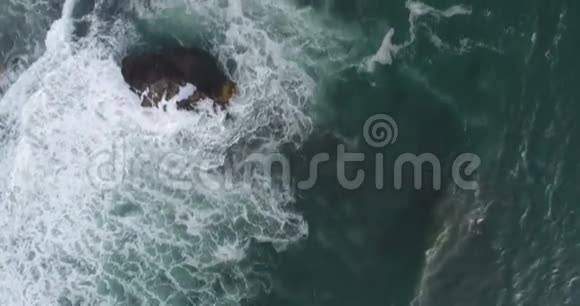 野自然和度假理念泡沫海洋海浪在礁石和岩石上飞溅的空中镜头美丽的亚洲视频的预览图