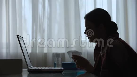 流鼻涕和感冒的女人在家里用笔记本电脑工作的剪影视频的预览图