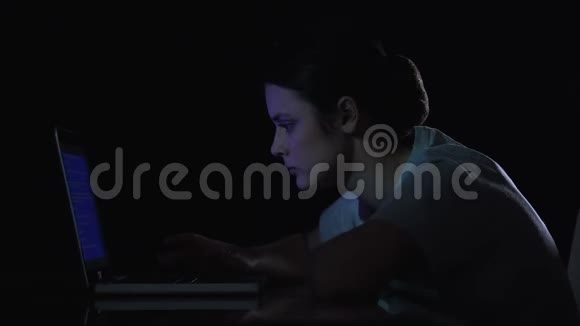 十几岁的女孩因为笔记本电脑的问题而哭泣坐在黑暗的房间里视频的预览图
