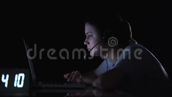 上夜班后自由职业女性关闭笔记本电脑取下耳机视频的预览图