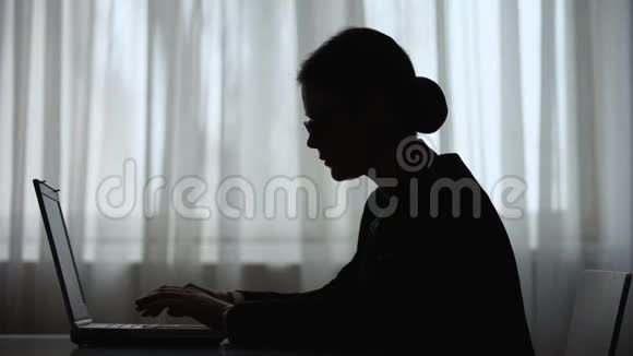 女性剪影在夜间工作时尖叫并关闭笔记本电脑压力过大视频的预览图