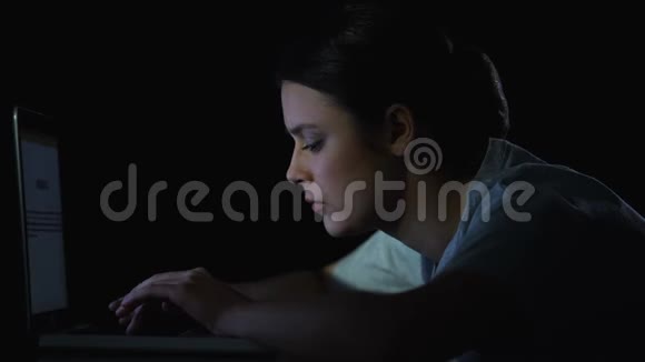 女孩程序员在笔记本电脑上打字深夜打哈欠在做程序视频的预览图