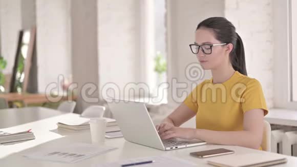 专注于现代办公室笔记本电脑的年轻女性设计师视频的预览图