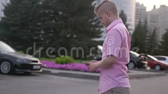 手拿手机的英俊商人走在街上视频的预览图