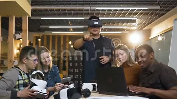 一群专注于笔记本电脑平板电脑工作的人而他们的年轻男性小丑则戴着虚拟现实眼镜玩得很开心视频的预览图