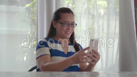 女人手拿着手机在桌子上和朋友在申请视频的预览图