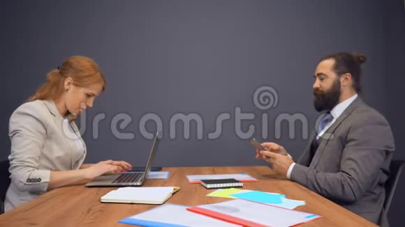 同事们坐在一起女商人正在集中精力开发笔记本电脑视频的预览图