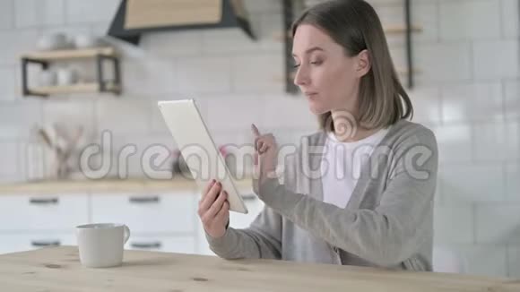 雄心勃勃的年轻女子在桌上做视频聊天视频的预览图