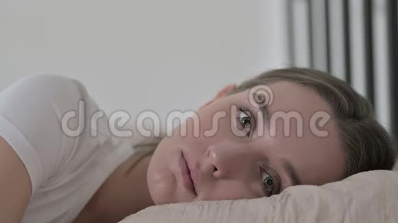 失眠的病态年轻女性躺在床上视频的预览图