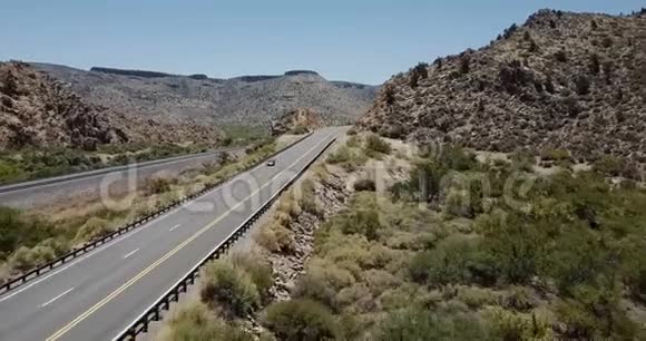 无人机跟随银色MPV汽车行驶在雄伟的阳光明媚的沙漠岩石山道路上阳光明媚的夏季亚利桑那州美国度假视频的预览图
