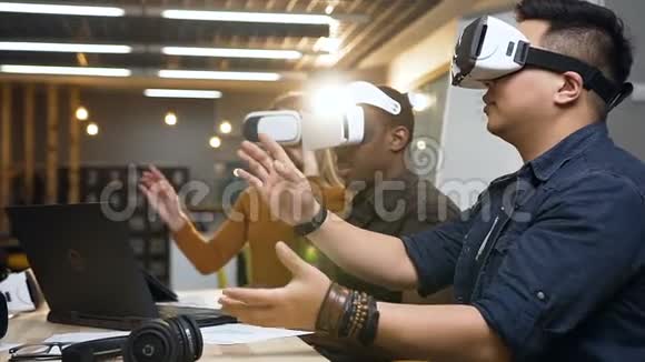 三名多民族工人在现代办公室中使用虚拟现实眼镜视频的预览图