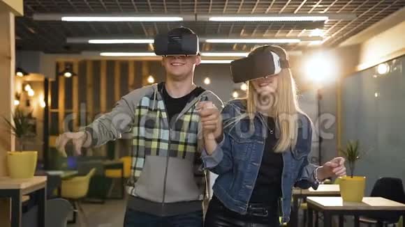 年轻的男女牛仔在现代办公室玩虚拟现实眼镜视频的预览图
