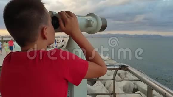 一个小男孩看着公共望远镜视频的预览图