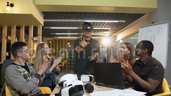 专注的日本男子使用虚拟现实眼镜而他的牛仔鼓掌他视频的预览图