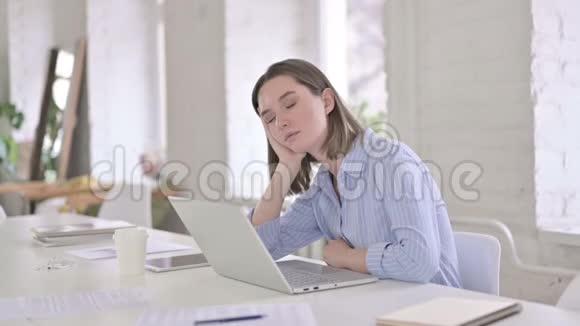 疲惫的年轻女子在现代办公室快速打盹视频的预览图