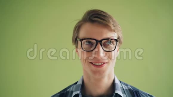 傻男学生旋转眼睛做滑稽面孔的特写肖像视频的预览图