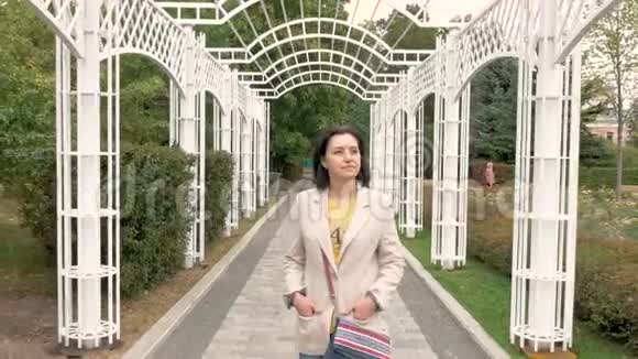白种人中年妇女在一个美丽的城市公园里沿着一条小路慢慢地走着视频的预览图