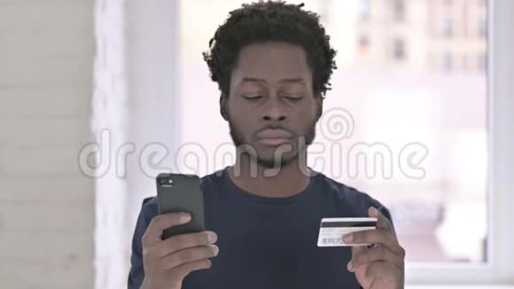 非裔美国年轻人在智能手机上在线支付的画像视频的预览图