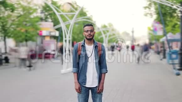 阿拉伯年轻人拿着背包站在繁忙的街道上时间流逝视频的预览图