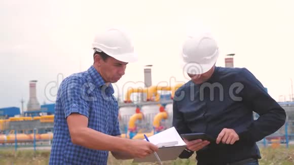 两名工程师在一家生产天然气的天然气工厂工作行业业务团队合作理念工人和工程师视频的预览图