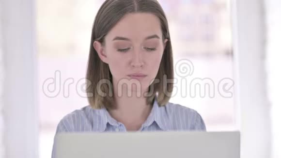 雄心勃勃的青年妇女在笔记本电脑上工作的肖像视频的预览图