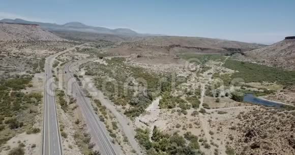 美国亚利桑那州夏季壮丽的沙漠岩石山丘道路和晴朗天空的史诗航空全景公路旅行概念视频的预览图