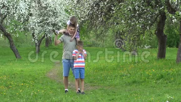 父亲带着儿子和女儿在花园里玩得很开心慢动作视频的预览图
