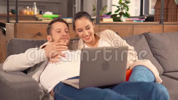 恋爱中的情侣躺在舒适的沙发上视频的预览图