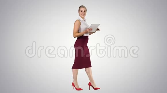 女性使用数字平板电脑行走并在渐变背景下与相机交谈视频的预览图